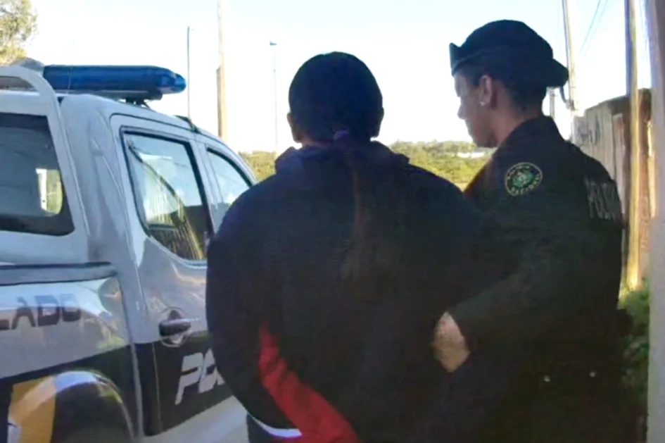 Mujer requerida siendo llevada por la policia