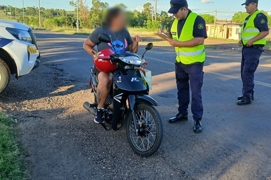 Una persona en moto siendo controlada por dos policías